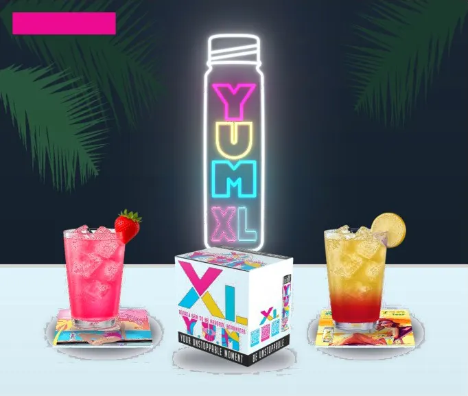 YUM XL bottles and drinks on a bar with the YUM sign
